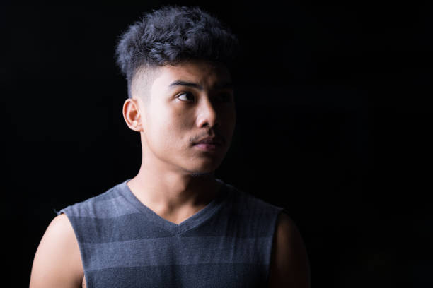 istock Face of young Asian man thinking while looking up at night outdoors 1209164049