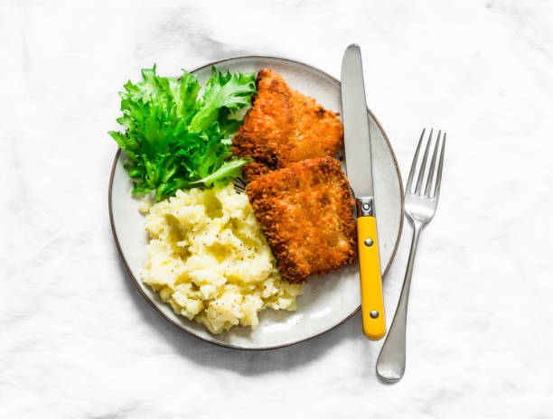 istock Comfort food - deep-fried fish and buttery mashed potatoes on a light background, top view 1209166577