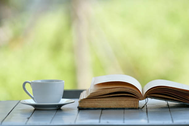 istock A white coffee mug and a book placed on a wooden table 1209166626