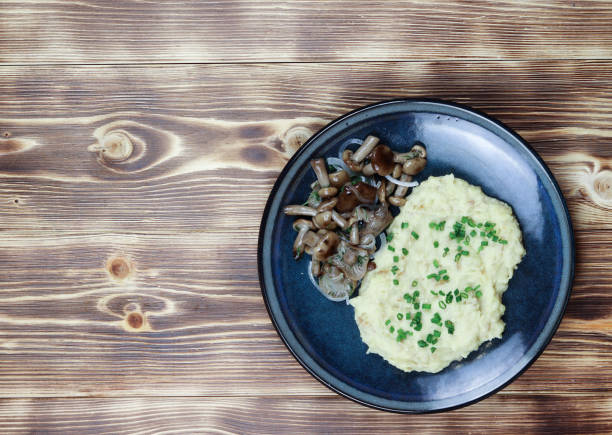 istock Mashed potatoes with marinated mushrooms on a plate on a wooden background. Top view 1209168493