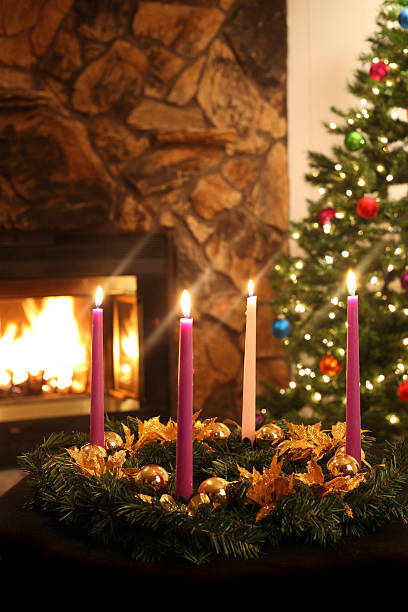 Advent wreath on table with fireplace and tree in background stock photo