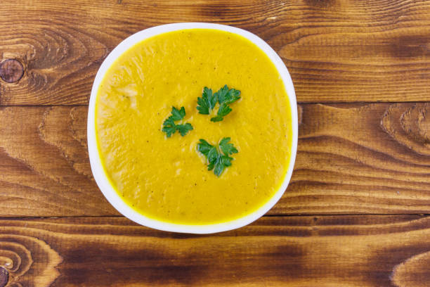 istock Pumpkin soup on a wooden table. Top view 1209172505