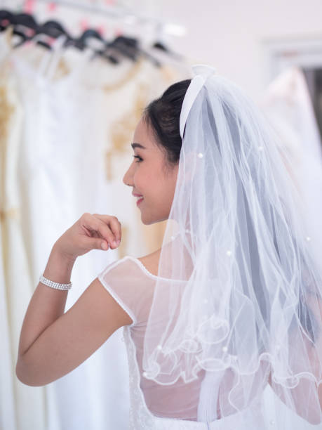 istock Asian bride adjusting her wedding dress 1209178849