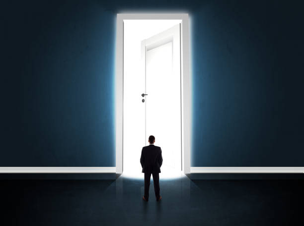 istock Business man looking at big bright opened door 1209179764