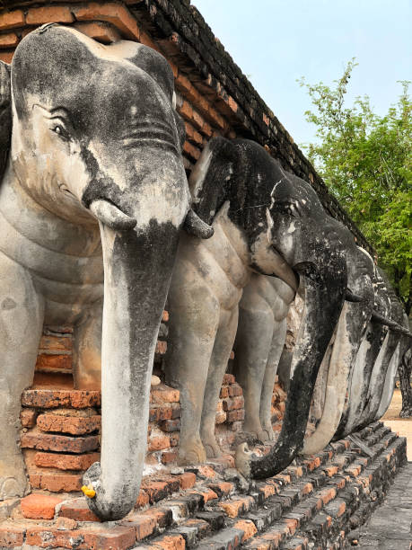 istock Elephant statues surround the Ancient Thai Temple (Wat Chang Lom). ancient, antique, architectural, architecture, asia, asian, attraction, blue, buddha, buddhism, buddhist, building, culture, elephant, famous, heritage, historic, historical, history, land 1209181242