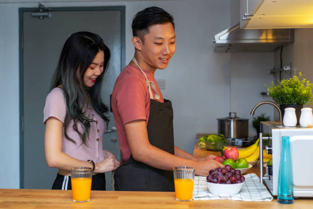 istock Girlfriend helping her boyfriend in the kitchen 1209182378