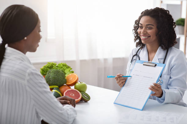 istock Positive dietologist showing patient medical chart while consultation 1209185403