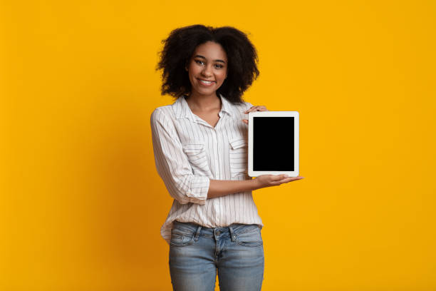 istock Happy Afro Girl Holding Digital Tablet With Empty Black Screen 1209185530
