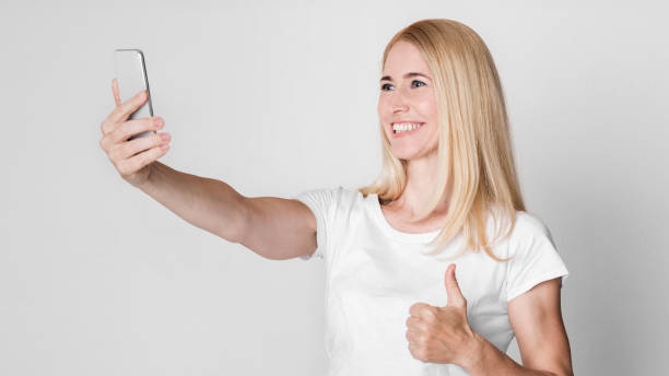 istock Aged woman making photo of herself at studio 1209185956