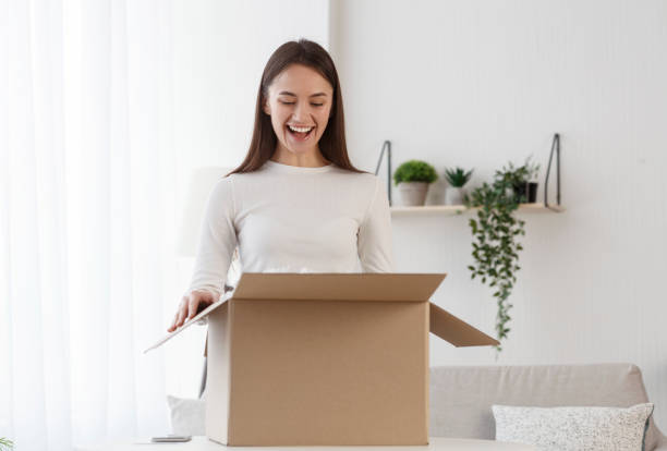 istock Woman unboxing cardboard box with protective foam pads inside 1209186600