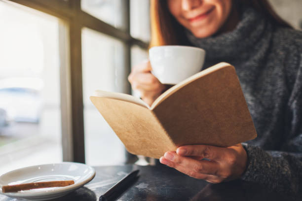 istock a beautiful woman reading a book while drinking coffee in the morning 1209193962