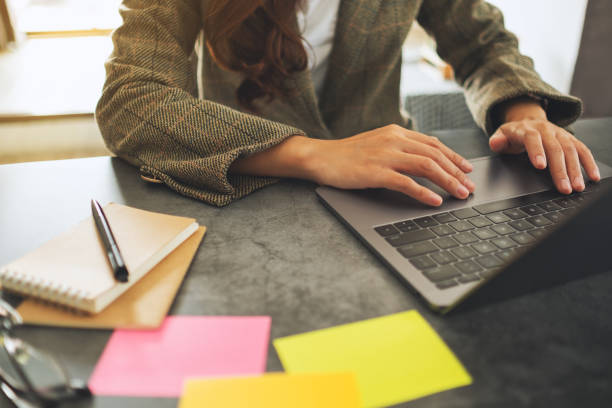 istock Businesswoman using and typing on laptop computer with paperwork on the table 1209194133