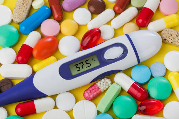 istock Pills and electronic thermometer (37.5 degrees) - medical background 1209194343