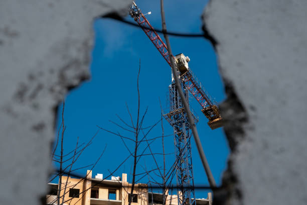 istock Crane on construction site. Crane and building under construction with blue sky from old damaged house 1209194509