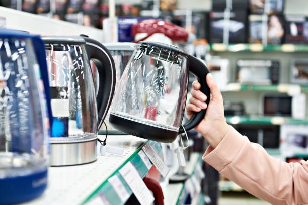 istock Electric kettle in buyer hand at shop 1209194529