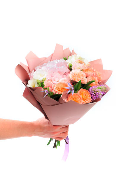 istock Mans hand holding Bouquet of mixed spring flowers  isolated on white background 1209194555
