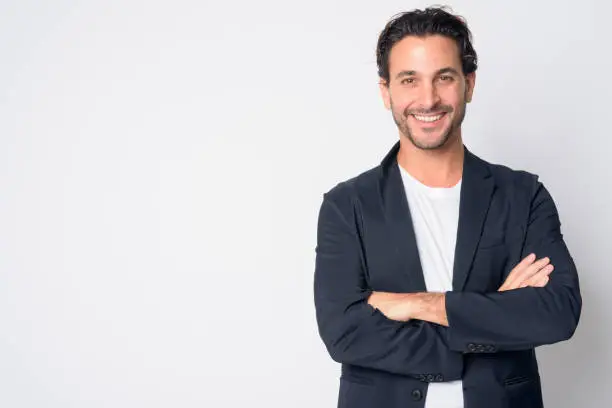 Studio shot of handsome Hispanic businessman wearing suit against white background