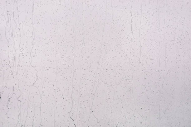 istock Raindrops on a gray surface. Flowing raindrops on the window. 1209198240