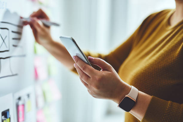 Woman with mobile phone and marker planning website