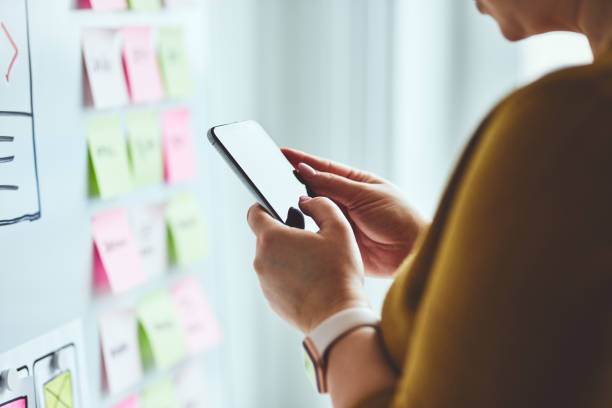 istock Woman with mobile phone planning website 1209198621