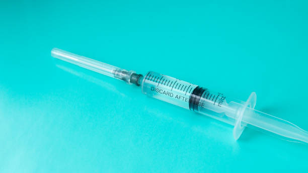 istock Medical syringe filled with medicine on a blue background. 1209199285