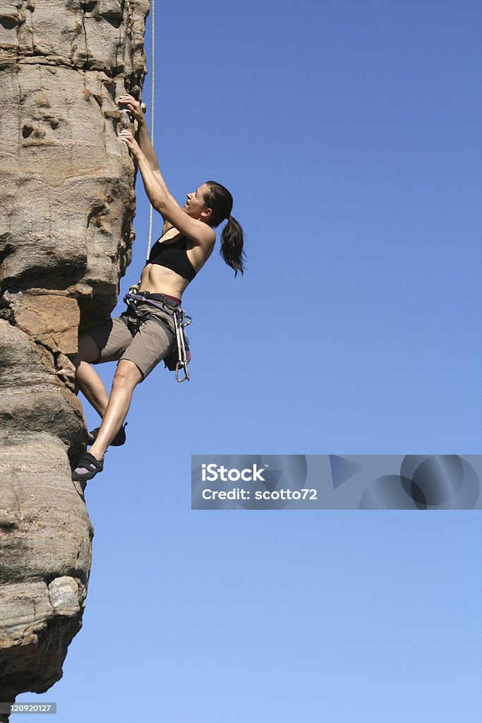 Woman rockclimbing A woman rock climbing at Margaret River, WA, Australia on a sunny day. Achievement Stock Photo