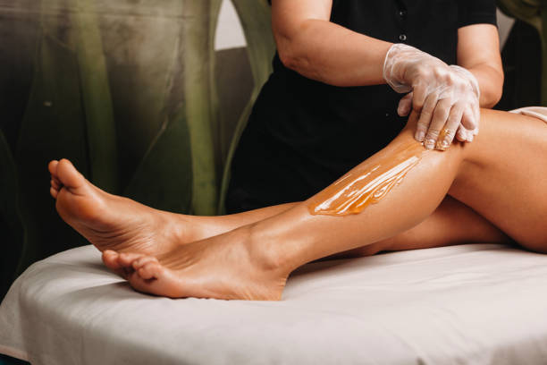 istock Caucasian spa professional having a sugaring session on legs for a charming woman 1209203120