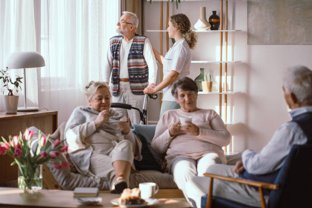 Meeting in living rom Meeting of a group of senior people in the living room in a nursing home common room stock pictures, royalty-free photos & images