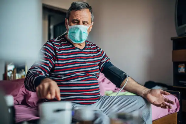 Photo of man measures his own blood pressure