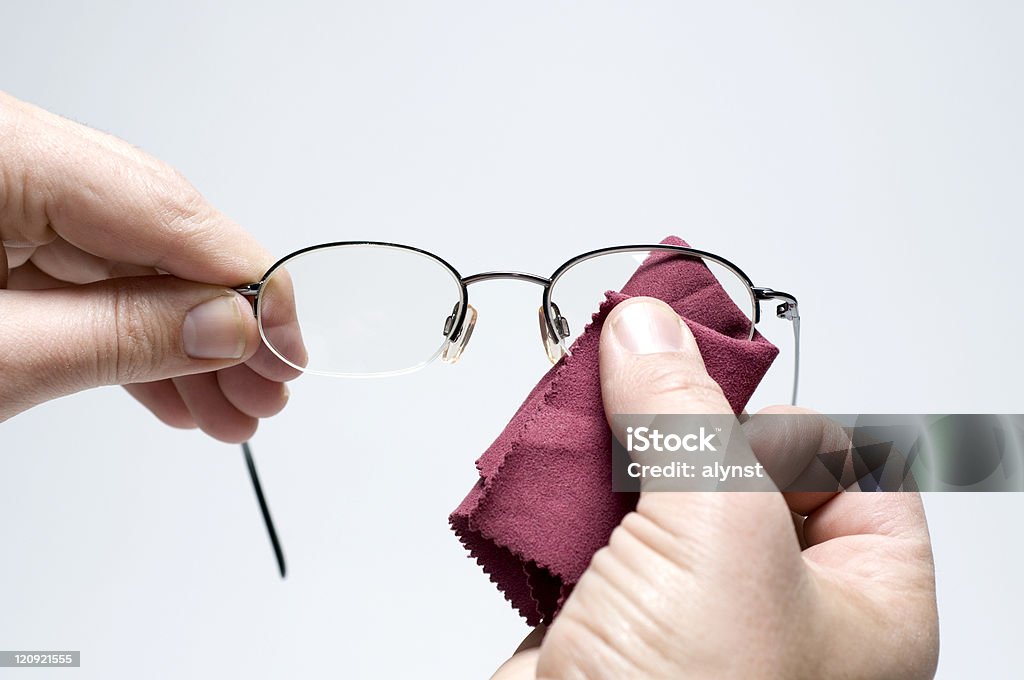 Cleaning Eyeglasses Male hands using a soft red lens cloth to clean a pair of eye glasses. Cleaning Stock Photo