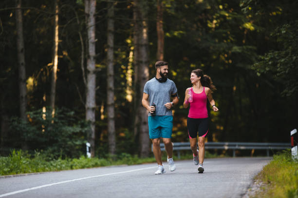 istock Young couple jogging in nature 1209216923