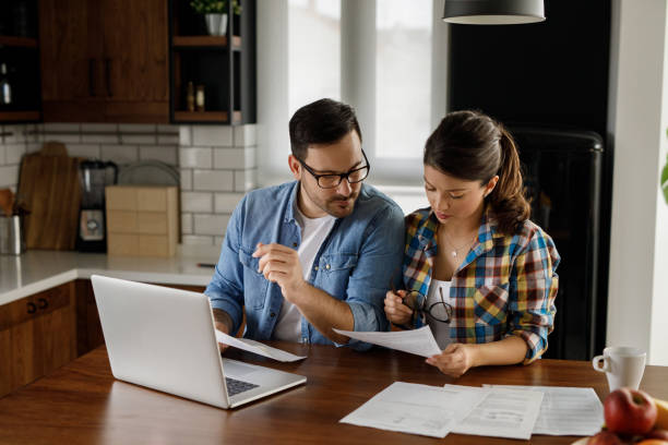 istock Young couple working on their finances together at home 1209217964
