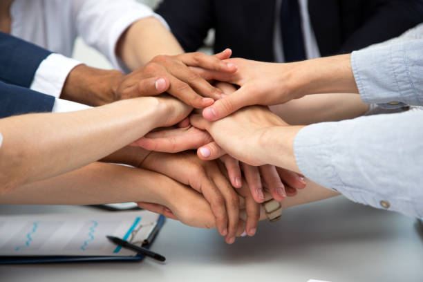 istock International business team showing unity with their hands 1209218089