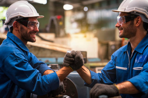 ingenieure und techniker arbeiten gemeinsam an den händen. ingenieure sicherheitswesten und hardhats machen deal und hände schütteln zusammen für den erfolg. - industriearbeiter stock-fotos und bilder