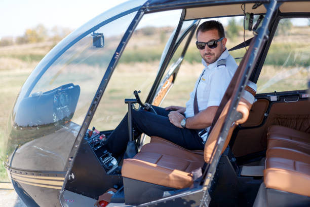 Helicopter pilot in uniform sitting in cockpit Helicopter pilot in uniform sitting in cockpit and waiting for flight helicopter seat stock pictures, royalty-free photos & images