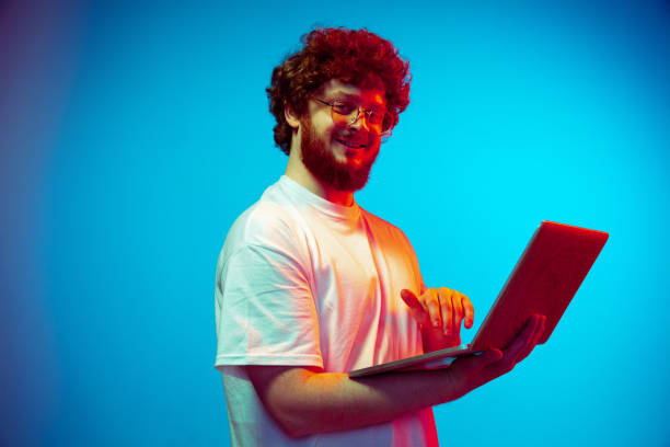 istock Caucasian man's portrait isolated on blue studio background in neon light 1209224750