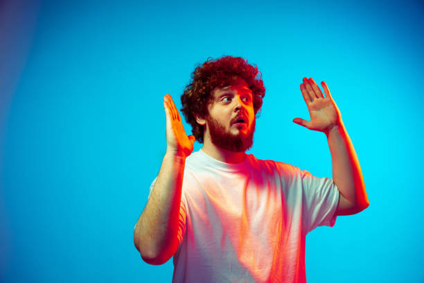 istock Caucasian man's portrait isolated on blue studio background in neon light 1209224759