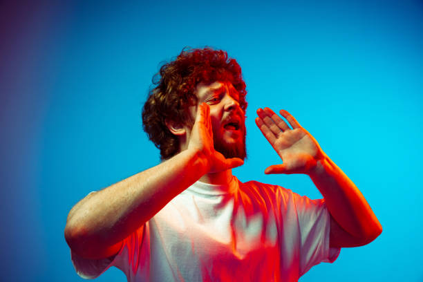 istock Caucasian man's portrait isolated on blue studio background in neon light 1209224812