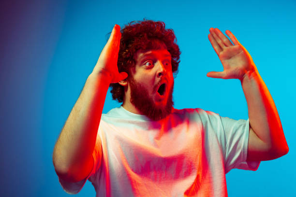 istock Caucasian man's portrait isolated on blue studio background in neon light 1209224832