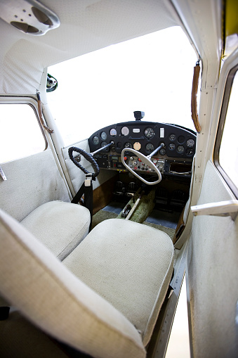 View of an old airplane cabin with all the instruments and control yokes.