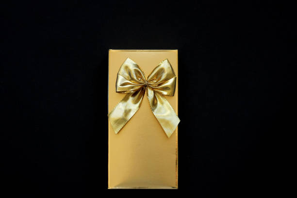 istock golden box with a golden bow on a black background 1209225805