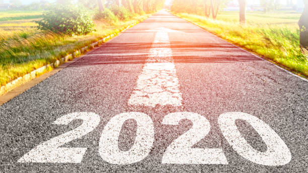 istock 2020 written on the asphalt. An arrow shows the way forward 1209225908