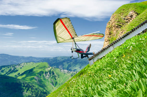 hang glider pilotos corre desde pendiente empinada en lo alto de las montañas. - paragliding sport austria parachuting fotografías e imágenes de stock