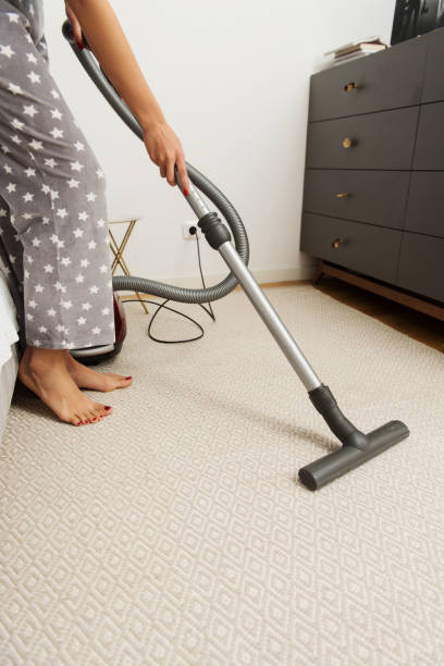 istock Woman vacuuming carpet, disinfection 1209228206