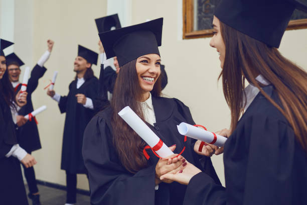istock Female graduates with diplomas in their hands hugging 1209228453