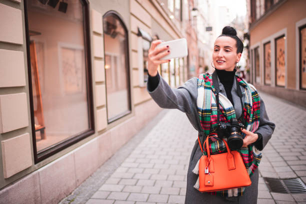 istock A lone woman smiling while taking a selfie holding up a dslr camera 1209230091