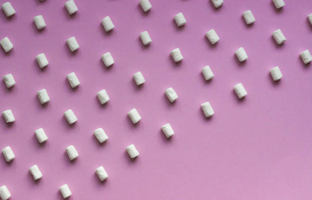 istock White marshmallows pattern on pink paper background. Geometric pattern of white marshmallows on color background. 1209230205