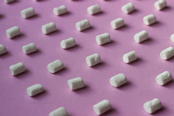 istock White marshmallows pattern on pink paper background. Geometric pattern of white marshmallows on color background. 1209230319
