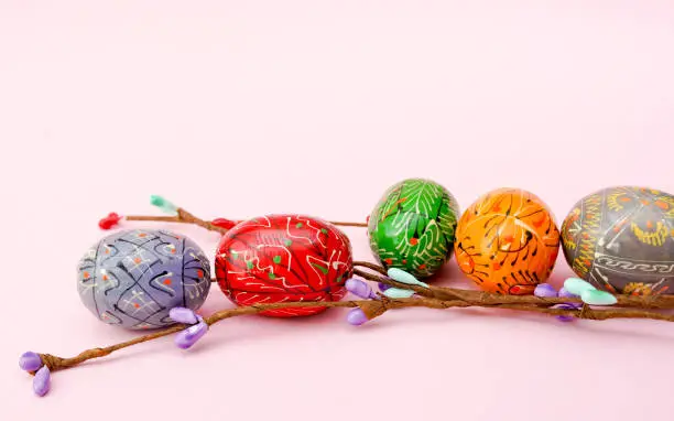 Easter eggs with branch on pink background, copy space