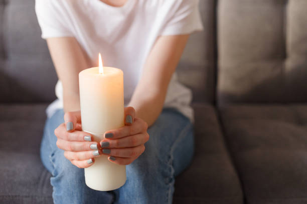 istock woman holding burning candle in her hands 1209231418